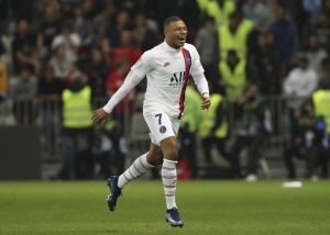 Mbappé comemorando um gol com os braços abertos.