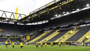 Os jogadores do Borussia celebram a goleada por 4 a 0 sobre o Schalke 04 com as arquibancadas do Signal Iduna Park completamente vazias.