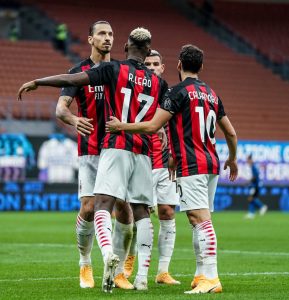Os jogadores do Milan se abraçam em campo para celebrar a vitória sobre a Internazionale, no derby de Milão.