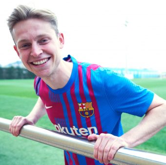 De Jong apoiado em uma grade, sorrindo e com o novo uniforme do Barça.