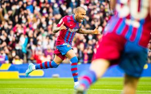 Dani Alves celebrando correndo e com os braços abertos o gol marcado contra o Atlético de Madrid.