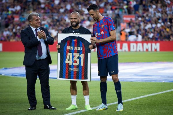 Alves recebe do presidente Joan Laporta e do capitão Sergio Busquets uma camisa com o total de jogos que disputou pelo clube. / Twitter: @FCbarcelona_br