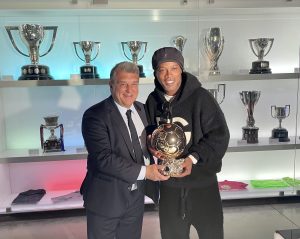 O astro Ronaldinho Gaúcho com o presidente do Barça, Joan Laporta, durante a entrega da Bola de Ouro ao museu do clube catalão.