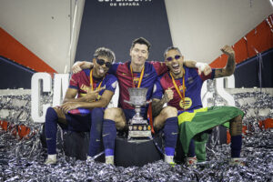 Lamine Yamal, Lewandowski e Raphinha, com a taça de campeão da Supercopa da Espanha 2025. / Twitter @FCBarcelona_br