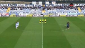 Jogadores, árbitro, assistentes e público fazem um minuto de silêncio para alguém que estava vivo.